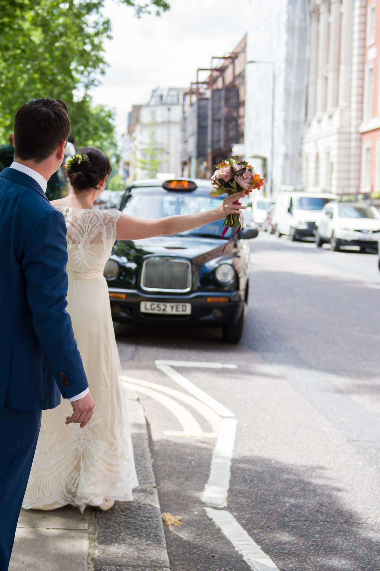 small and intimate wedding photography bride and groom hailing a taxi in London